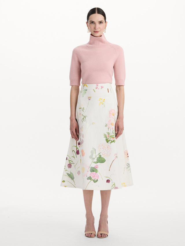 The model is wearing the faded mixed botanical denim midi skirt in the color white multi. Front view.