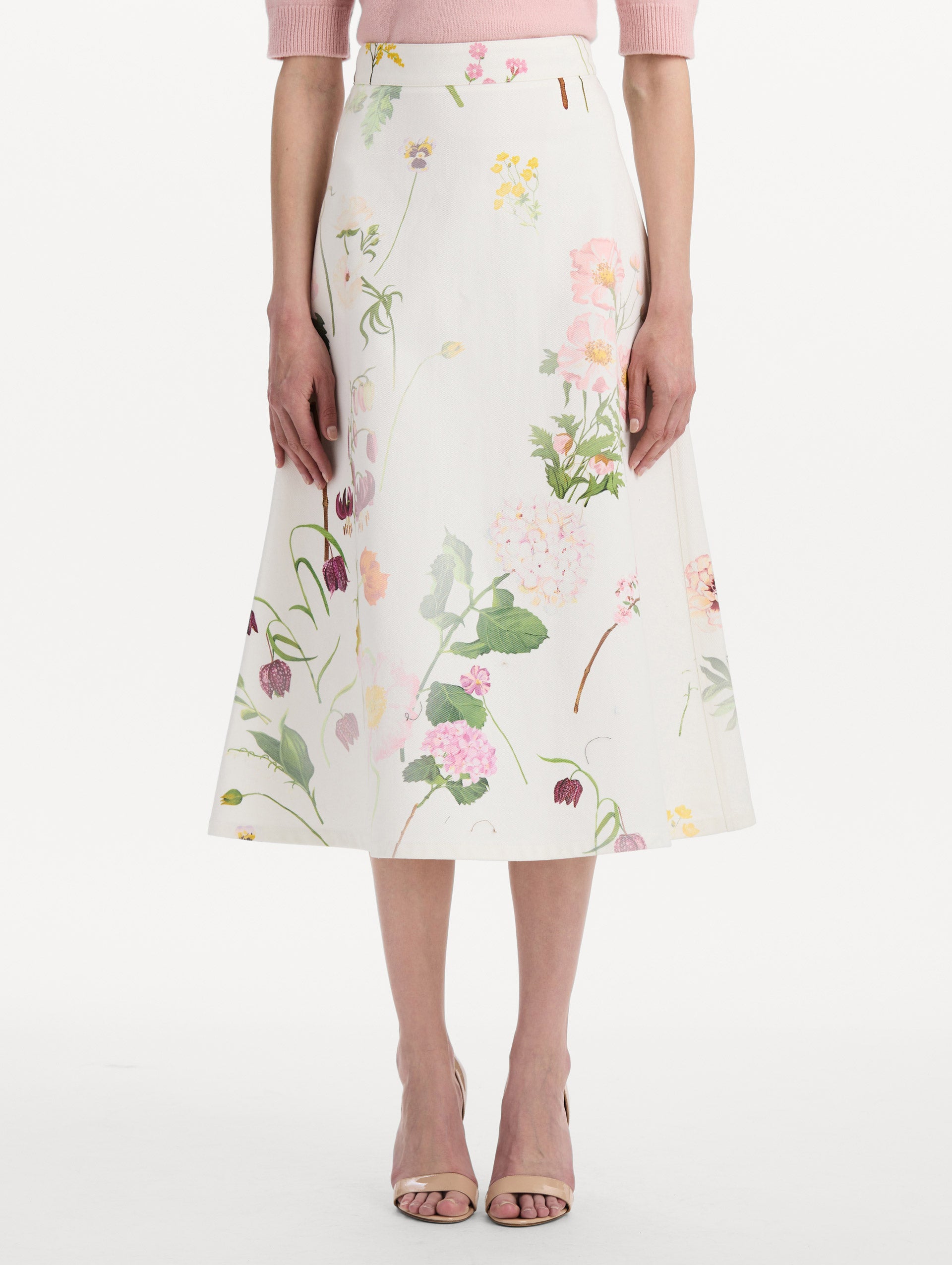 The model is wearing the faded mixed botanical denim midi skirt in the color white multi. Front view.