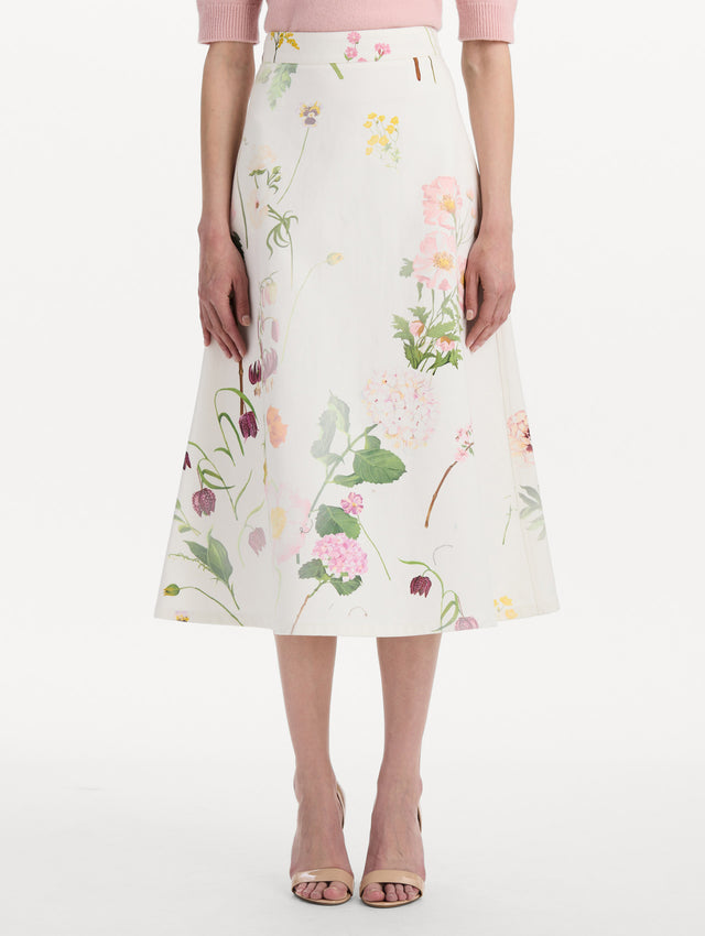 The model is wearing the faded mixed botanical denim midi skirt in the color white multi. Front view.