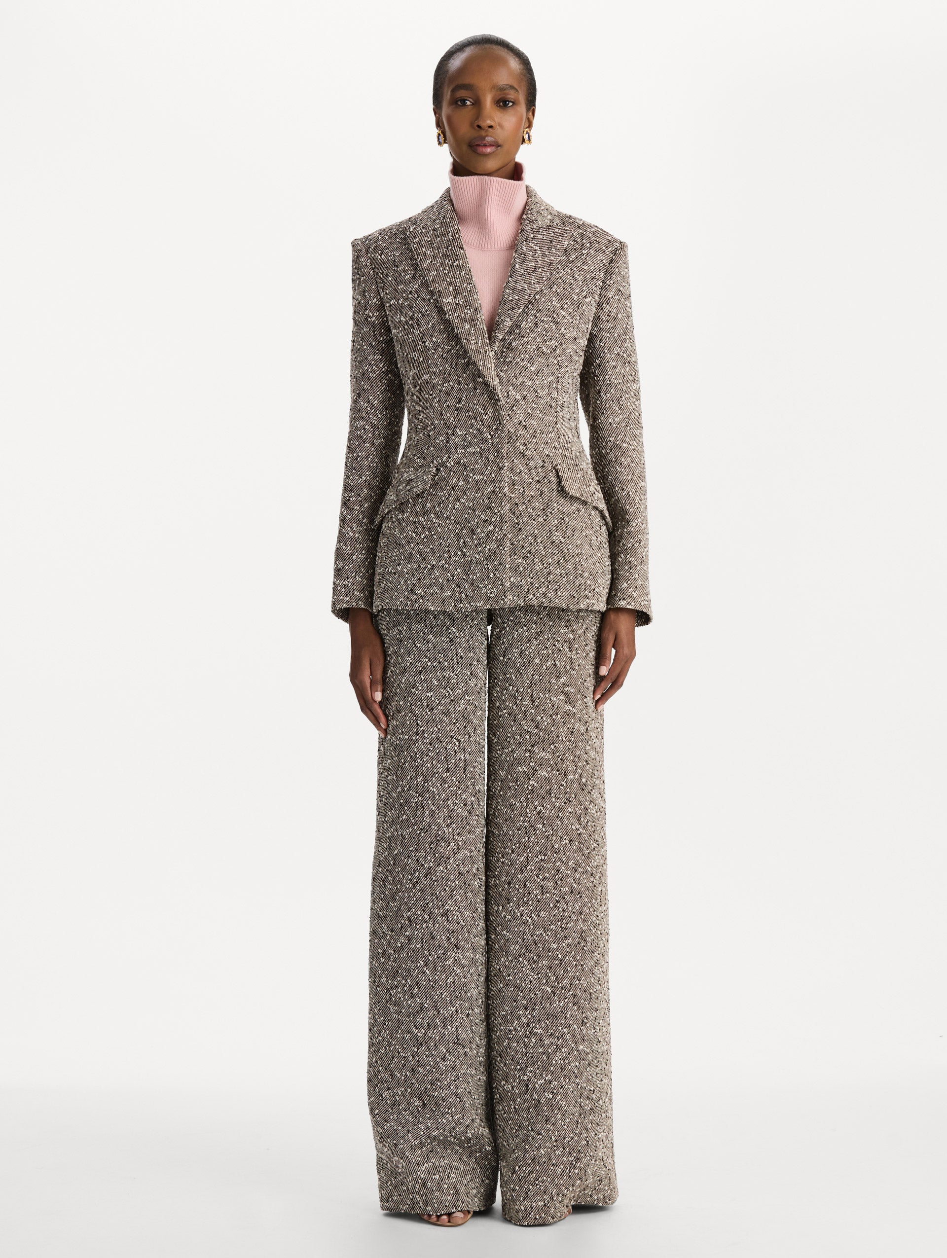 The model is wearing the slub wool tweed collared jacket with long sleeves in an ivory and brown palette. Front view. 