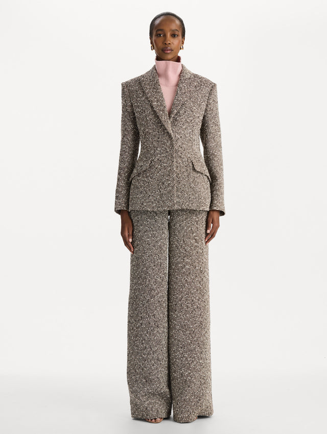 The model is wearing the slub wool tweed collared jacket with long sleeves in an ivory and brown palette. Front view. 