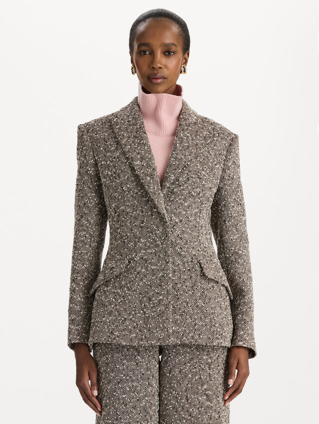 The model is wearing the slub wool tweed collared jacket with long sleeves in an ivory and brown palette. Front view. 