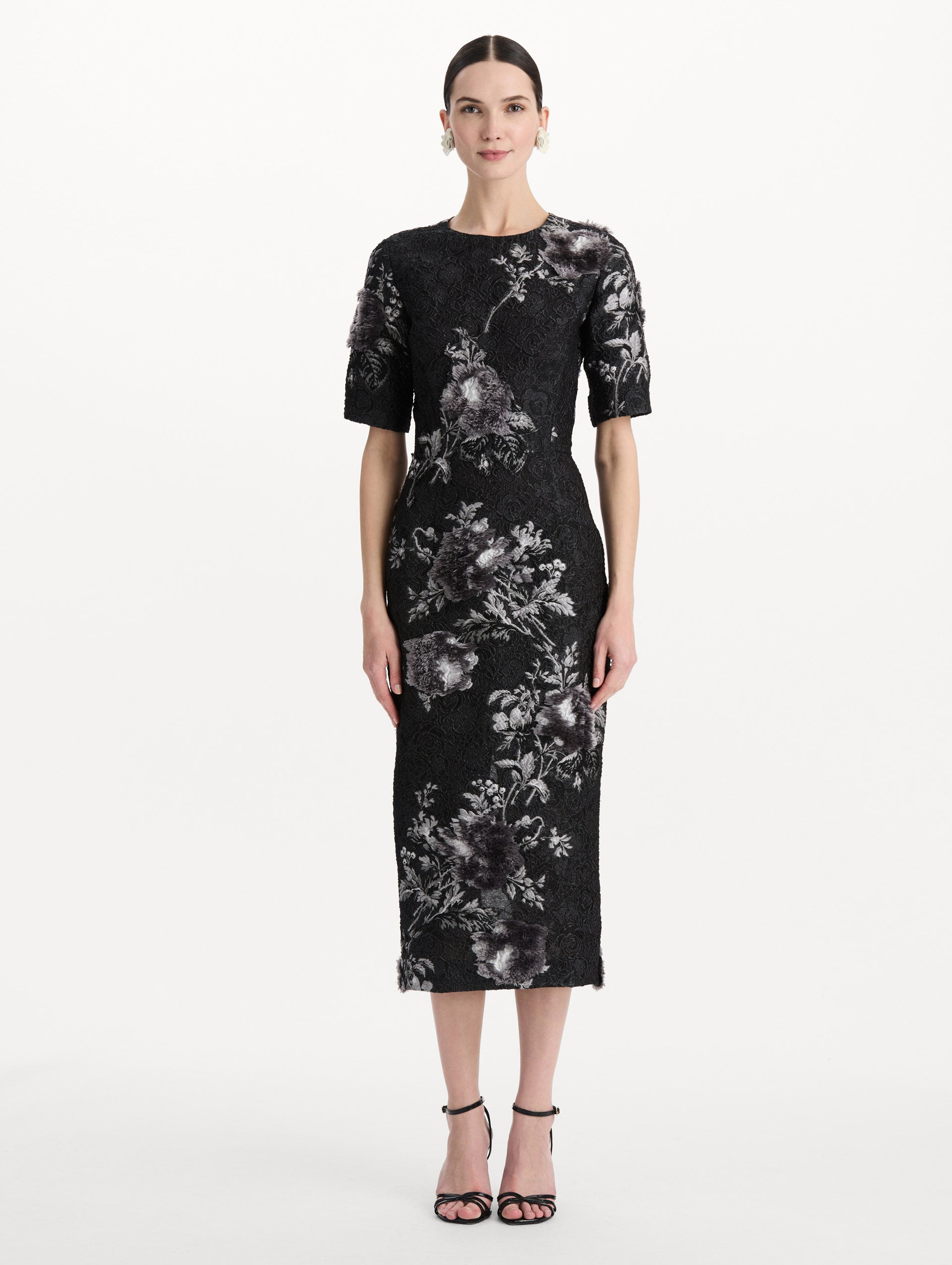 The model is wearing the peony fil coupé cocktail dress with midi sleeves in a white and carbon palette. Front view. 