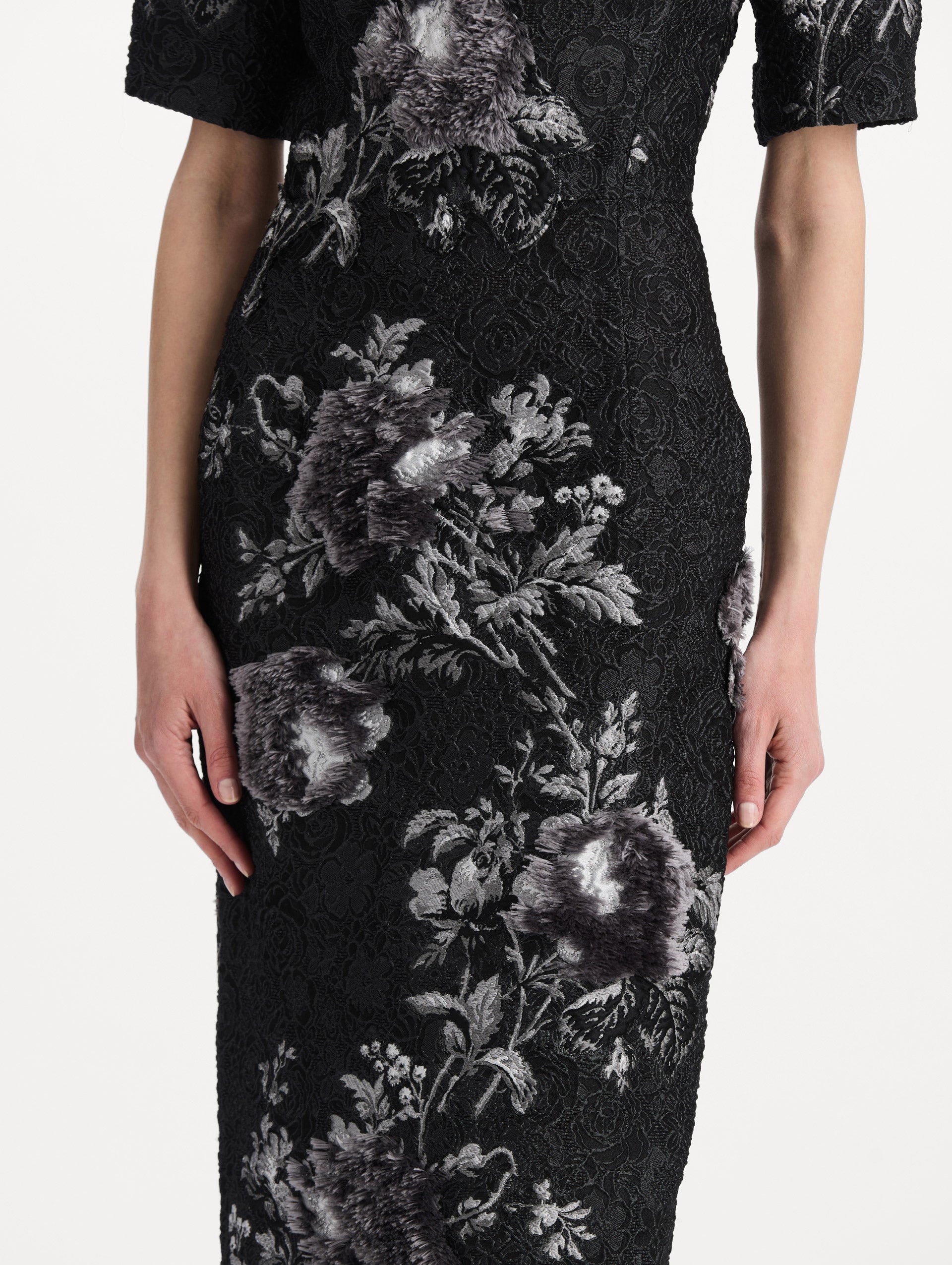 The model is wearing the peony fil coupé cocktail dress with midi sleeves in a white and carbon palette. Zoom view. 