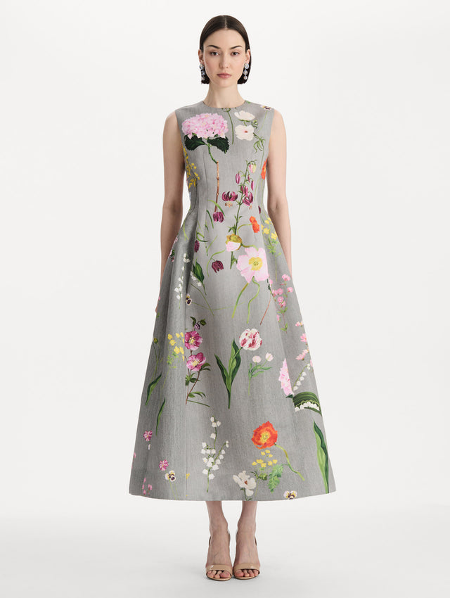 The model is wearing the mixed botanical faille cocktail dress with a sleeveless silhouette in the color grey multi. Front view. 