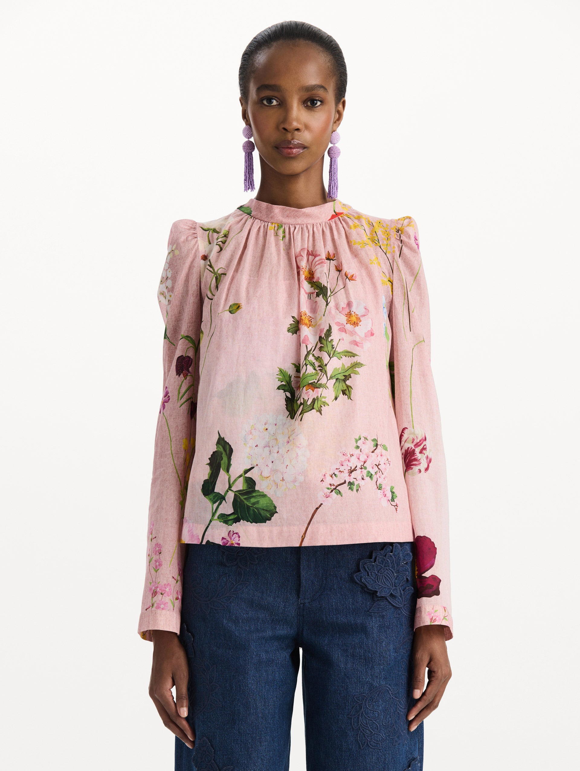 The model is wearing the mixed botanical tie-detailed blouse with a tie neckline and an all-over floral print in a blush multi palette. Front view. 