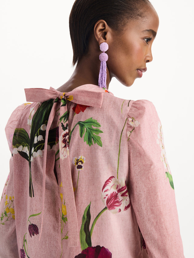 The model is wearing the mixed botanical tie-detailed blouse with a tie neckline and an all-over floral print in a blush multi palette. Zoom view. 