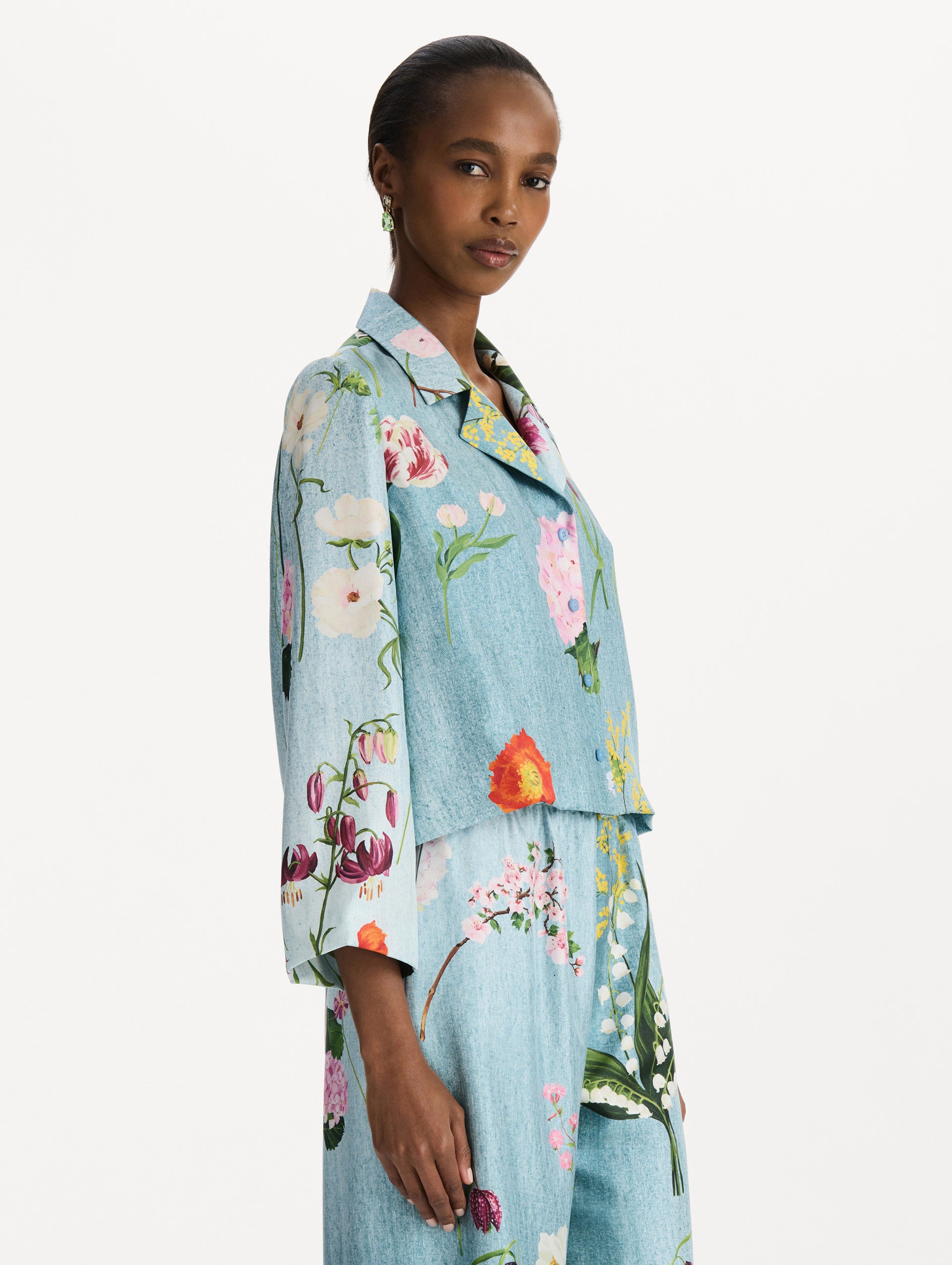 The model is wearing the mixed botanical silk twill blouse with long sleeves in the color blue multi. Side view. 