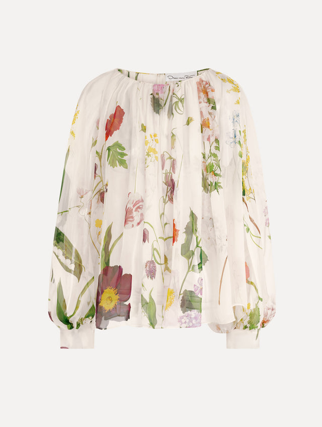 The model is wearing the mixed botanical silk chiffon blouse with long sleeves and an all-over floral print in ecru tones. 