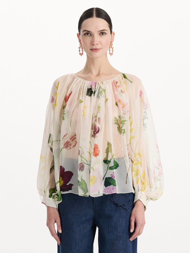 The model is wearing the mixed botanical silk chiffon blouse with long sleeves and an all-over floral print in ecru tones. Front view. 