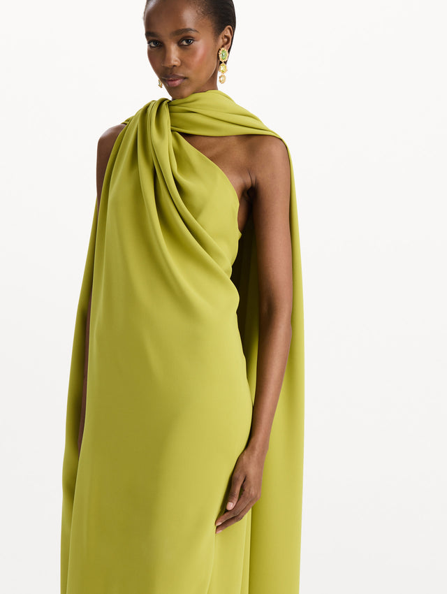 The model is wearing the drape-detailed georgette caftan with a halter neckline in the color peridot. Zoom view. 