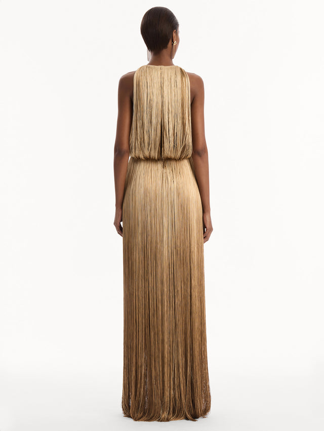 The model is wearing the Ombré Fringe Sleeveless Gown. Featuring layers of ombré fringe, a softly draped bodice, and elongated skirt. Back View.