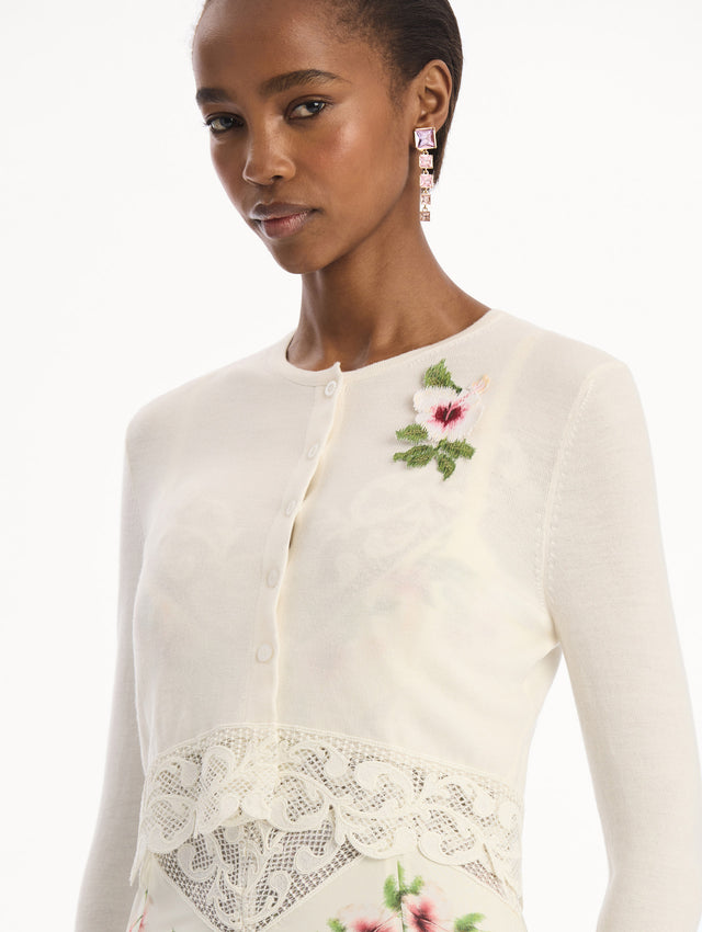The model is wearing the Chiné Hibiscus Threadwork Cropped Cardigan in Ivory. Featuring a threaded Chiné hibiscus and intricate guipure lace trim. Detail View.