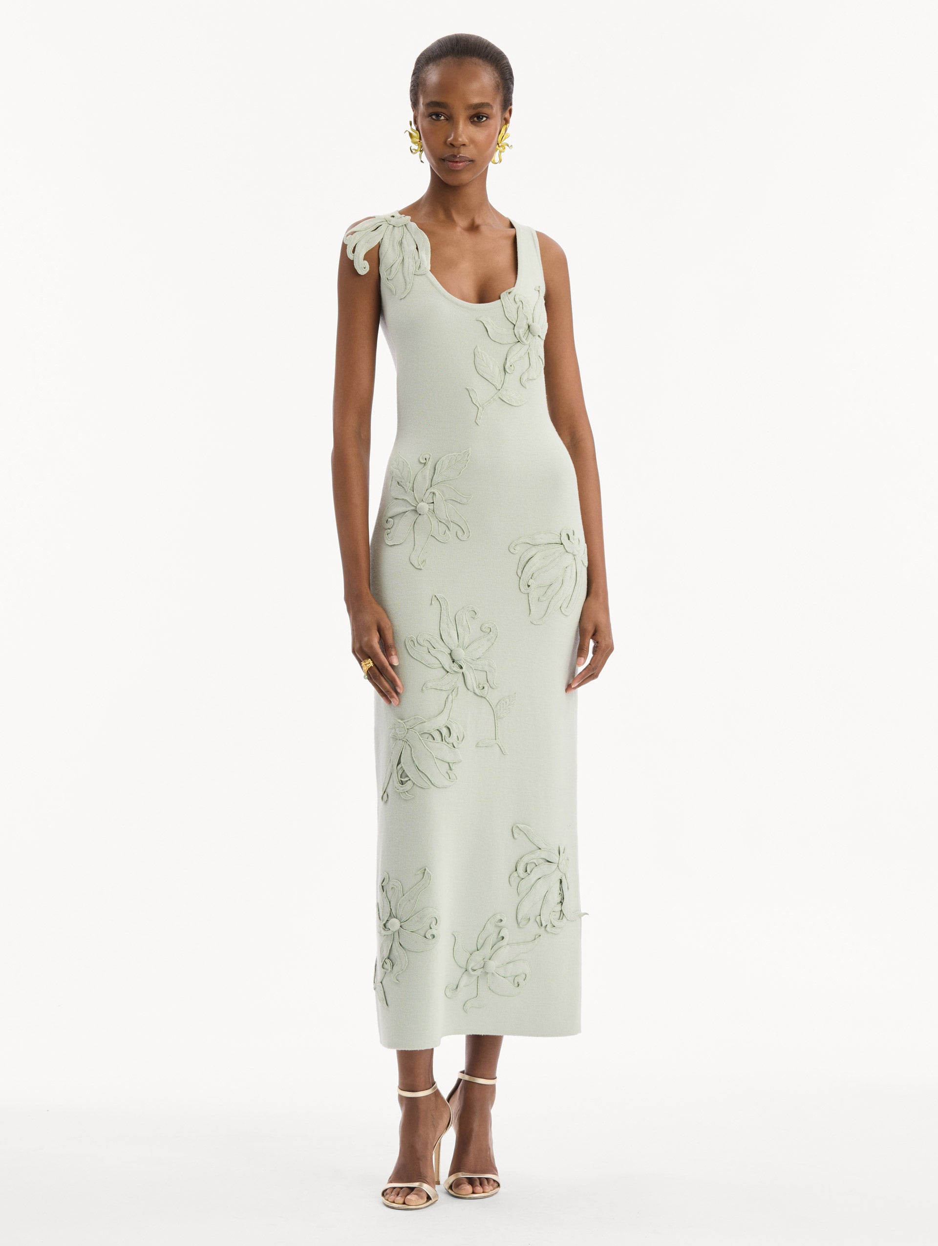 The model is wearing the Hibiscus Embroidered Knit Pencil Dress in Saltwater Blue. Featuring a structural hibiscus embroidery, a scoop neckline, and midi length. Front View.
