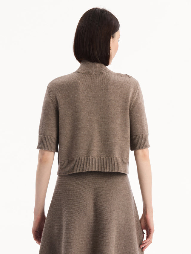 The model is wearing the Hibiscus Embroidered Knit Pullover. Featuring a high neckline and ribbed trim. Back View.