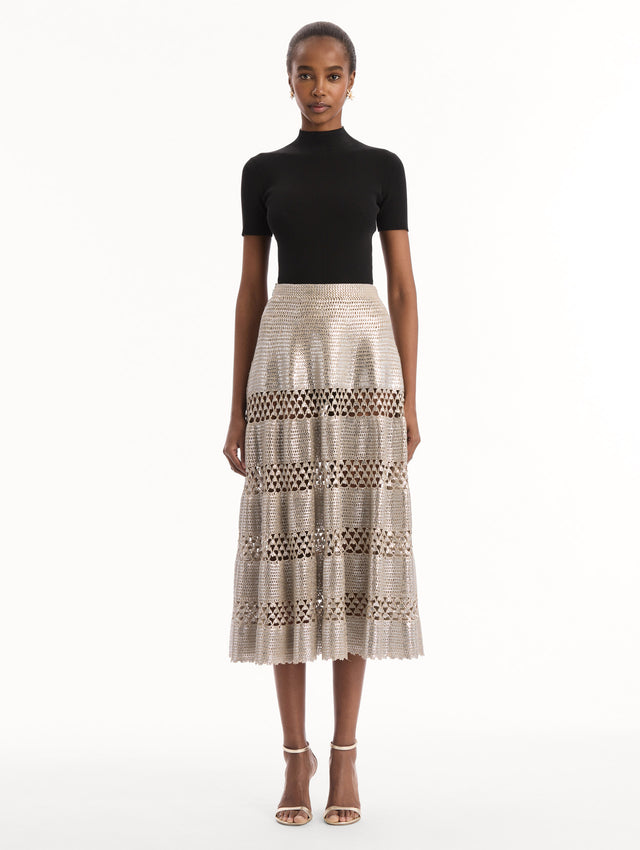 The model is wearing the Silver Foil Midi Skirt. Featuring a tiered silhouette with striped intricate openwork and midi length. Front View.