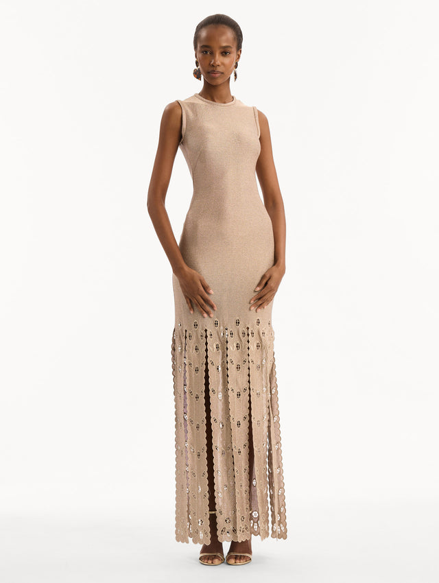 The model is wearing the Pineapple Fringe Metallic Jersey Dress. Featuring shimmering metallic jersey fabrication, a body-skimming silhouette, and pineapple-inspired fringe along the hem. Front View. 
