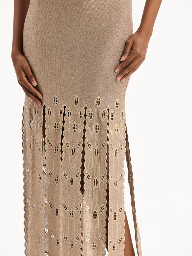The model is wearing the Pineapple Fringe Metallic Jersey Dress. Featuring shimmering metallic jersey fabrication, a body-skimming silhouette, and pineapple-inspired fringe along the hem. Detail View. 