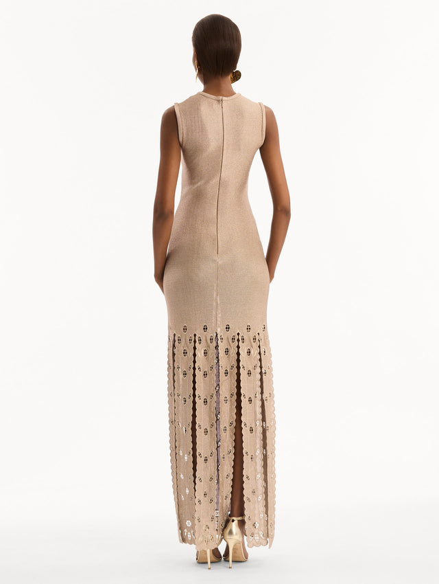 The model is wearing the Pineapple Fringe Metallic Jersey Dress. Featuring shimmering metallic jersey fabrication, a body-skimming silhouette, and pineapple-inspired fringe along the hem. Back View. 
