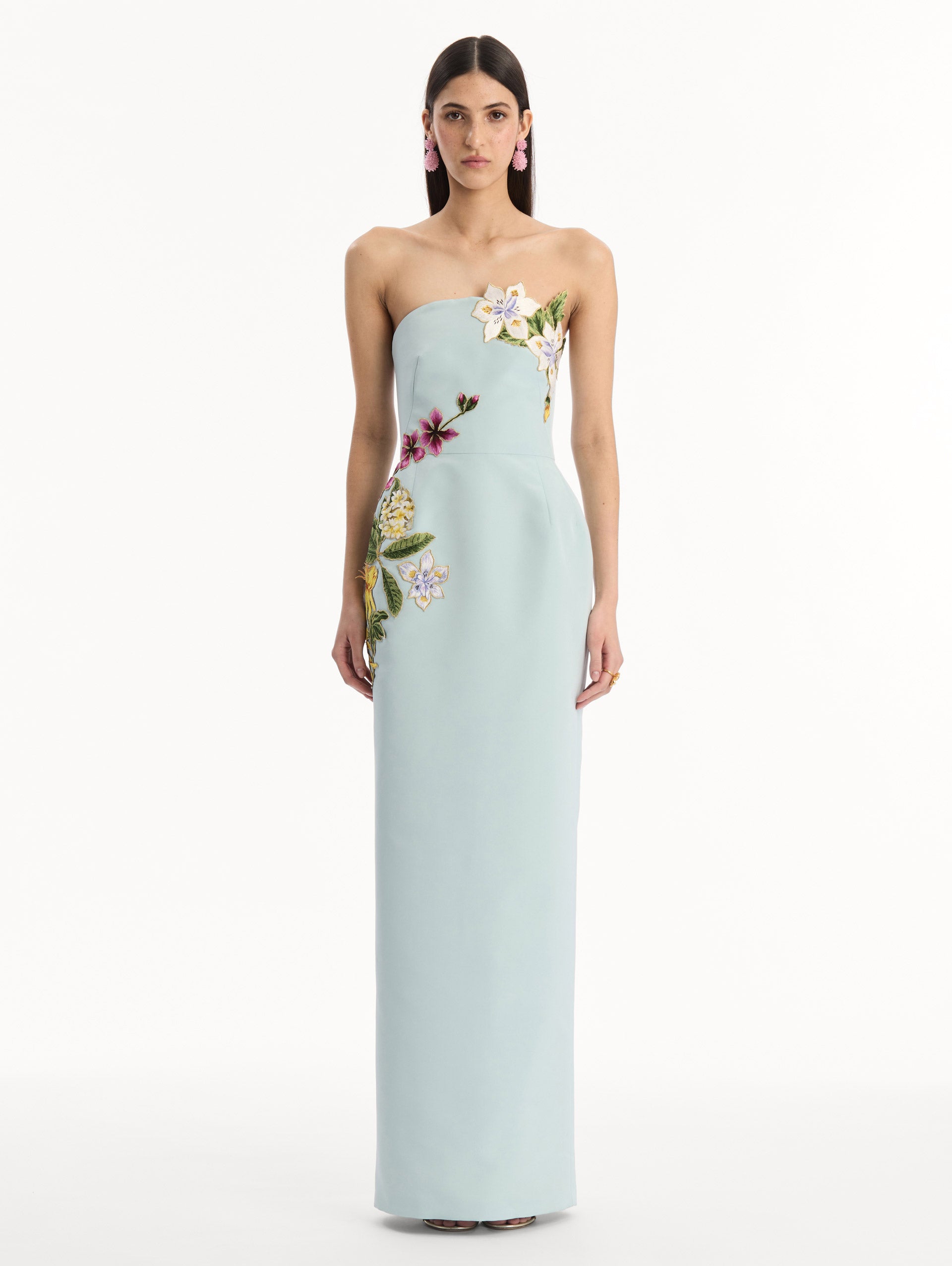 The model is wearing the Dominican Mixed-Floral Embroidered Gown in Saltwater Blue. Featuring Dominican floral embroidery, strapless neckline, and long, column silhouette. Front View.