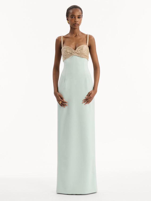 The model is wearing the Twist-Detail Metallic Column Gown in Saltwater Blue. Featuring a metallic twist-detail bodice and long, column silhouette. Front View.