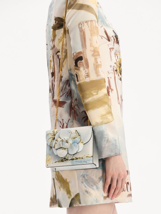 The model is wearing the Dominican Landscape Printed Mini TRO Bag in Saltwater Blue. Detail View.
