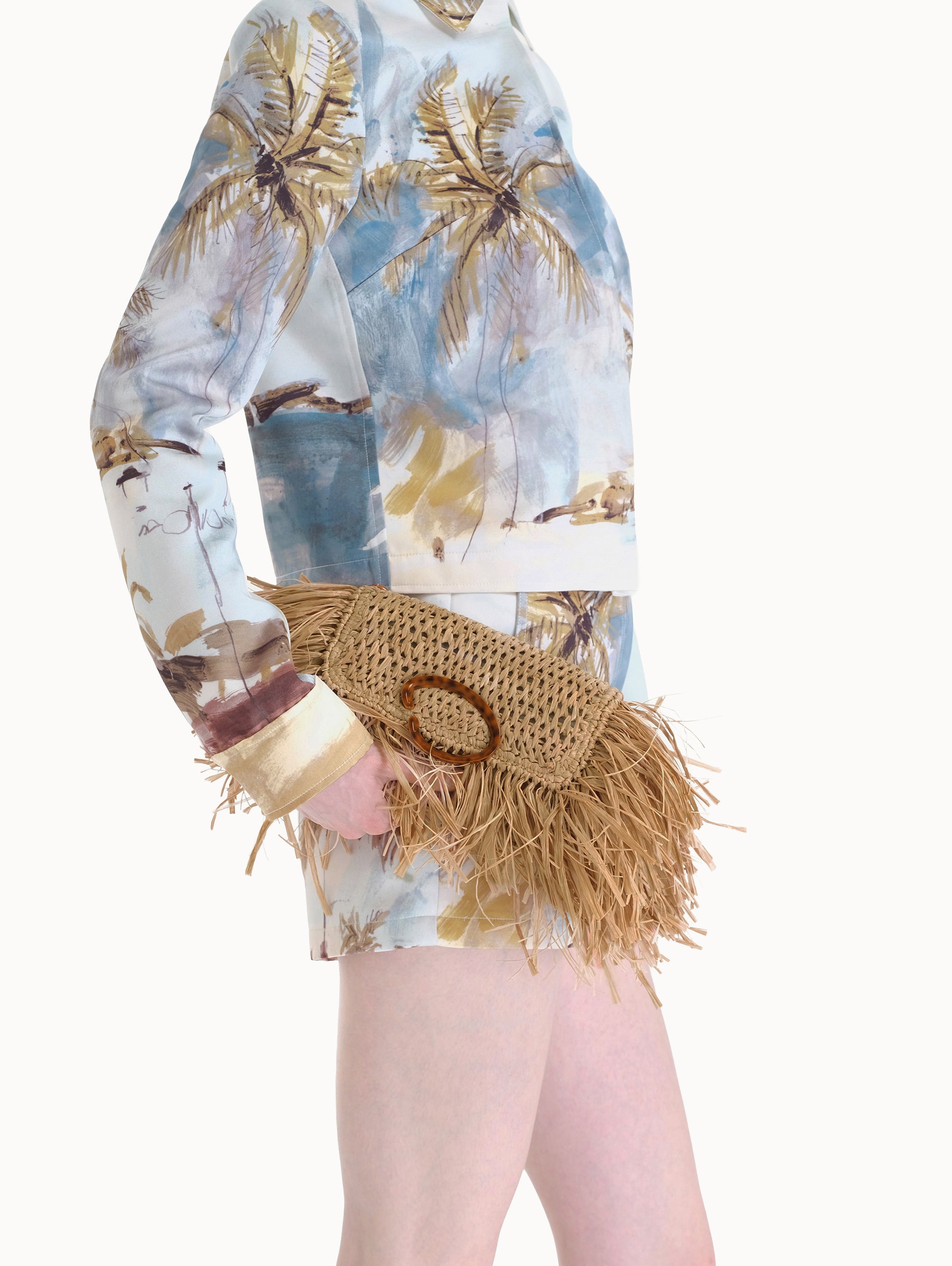 The Raffia Fringe O Pochette in the color natural with fringe detailing and a tortoise-accented O clasp.