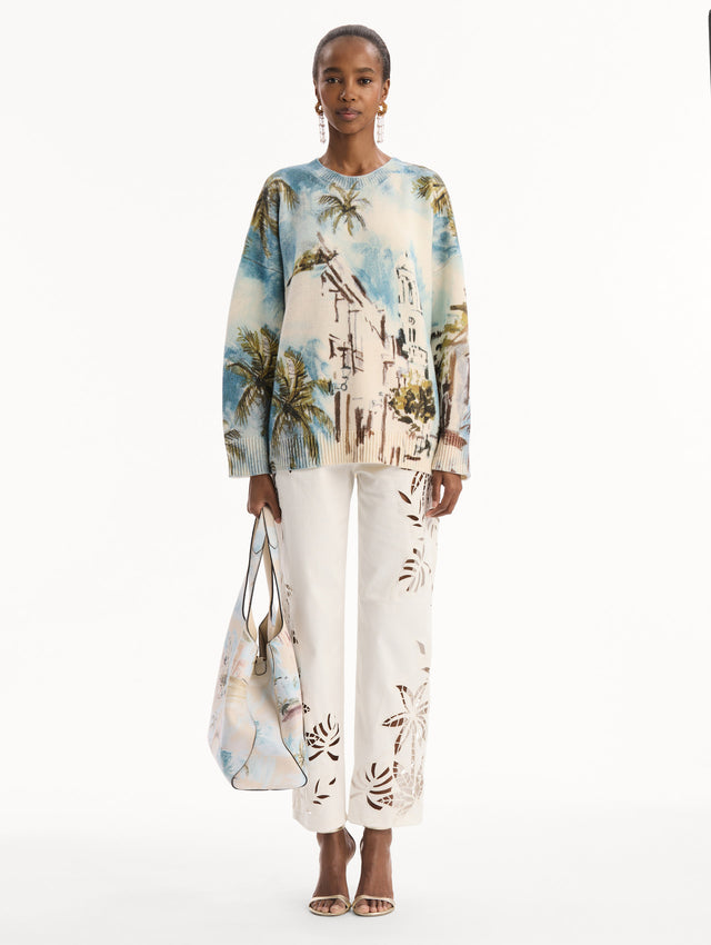 The model is wearing The Topaz bag adorned with the Dominican Landscape print. Full-Body View.