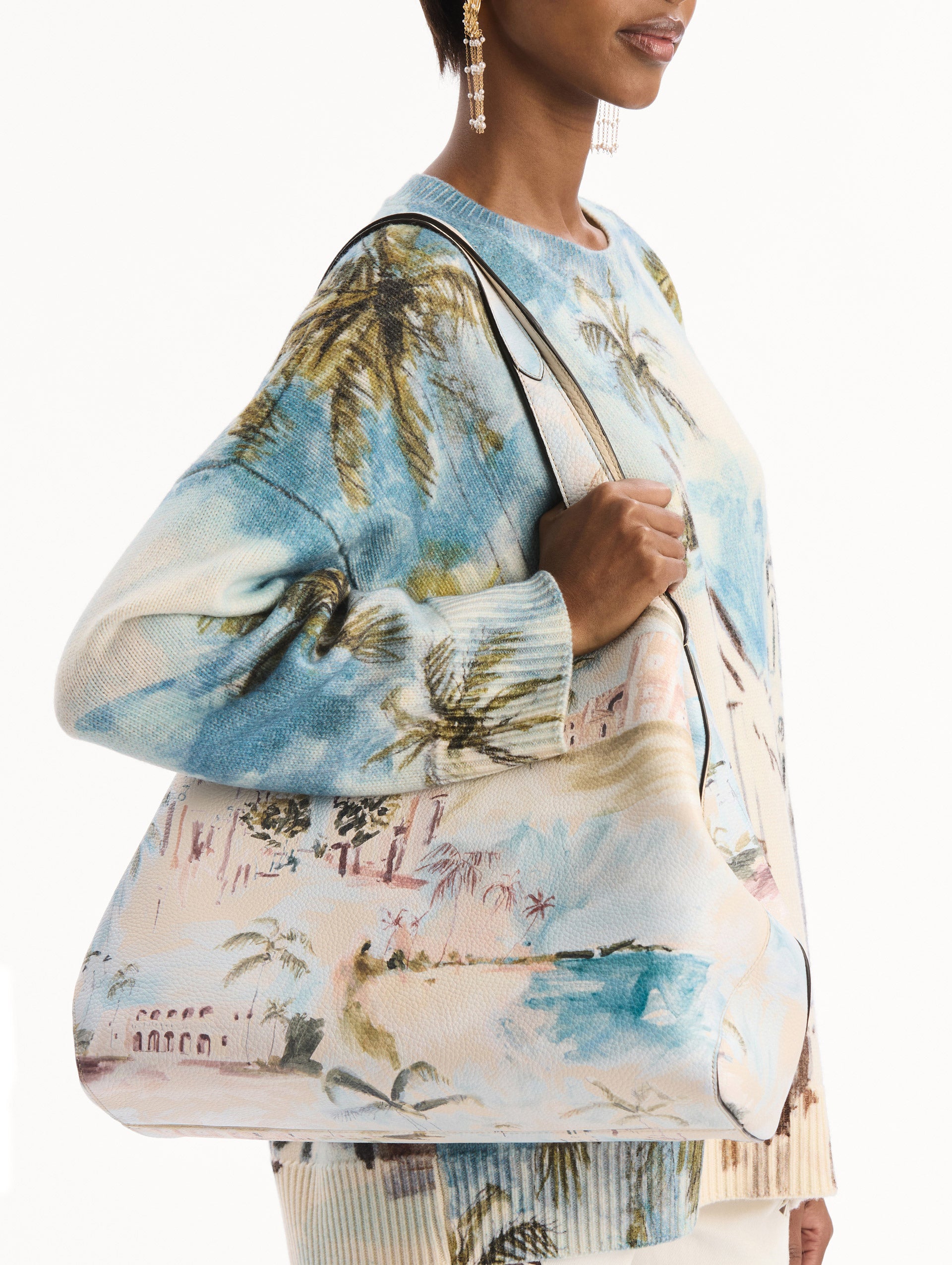 The model is wearing The Topaz bag adorned with the Dominican Landscape print. Detail View.