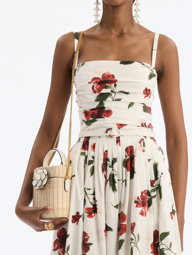 Small Bucket Shoulder bag  wicker. White top handle, white flower closure. Gold chain strap. Side View.