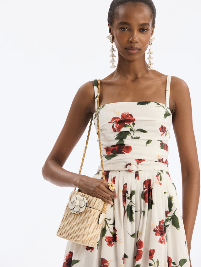 Small Bucket Shoulder bag  wicker. White top handle, white flower closure. Gold chain strap. Side View.