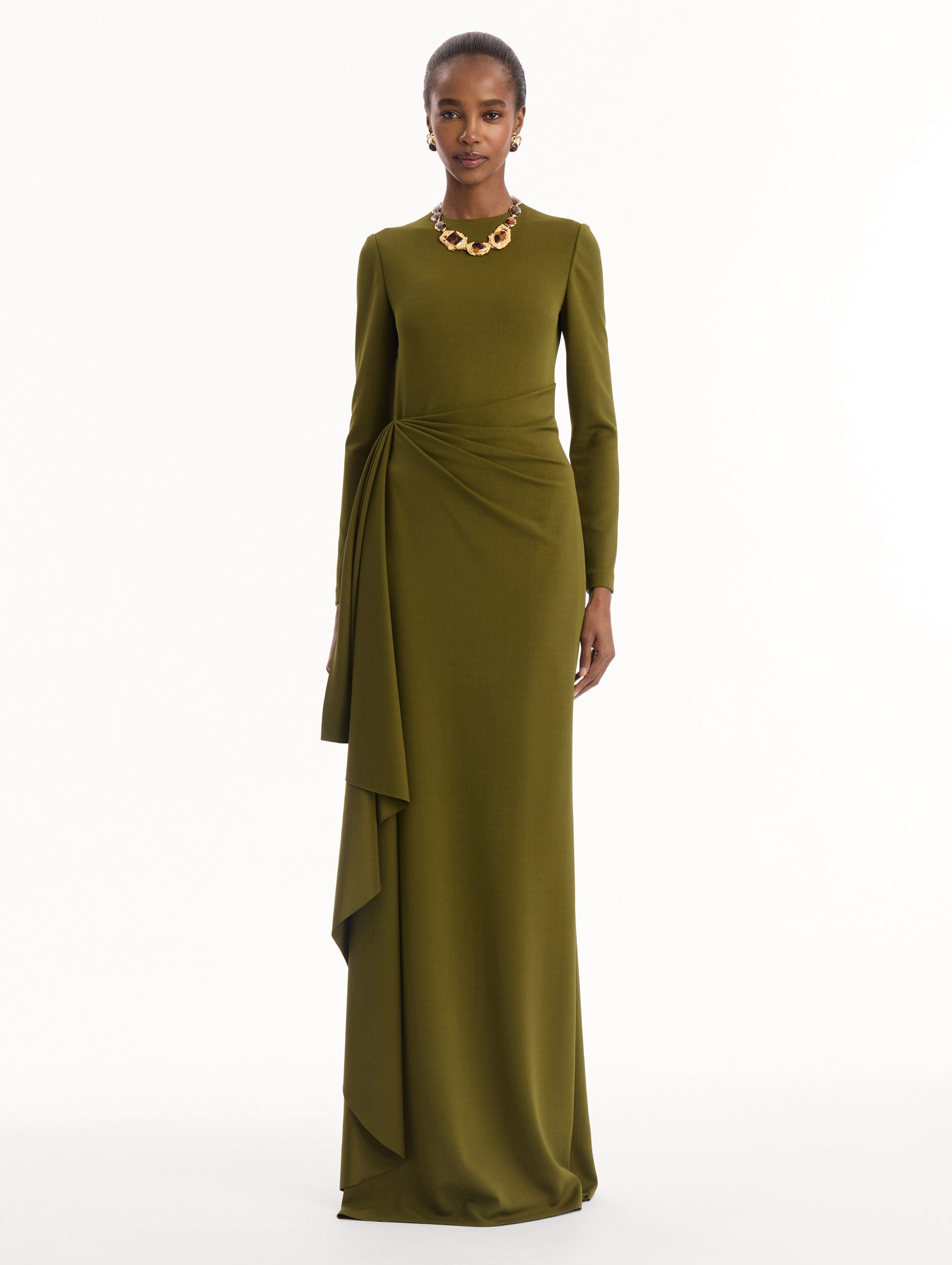 The model is wearing the Drape-Detail Jersey Gown in olive green. Featuring long sleeves, a body-skimming silhouette, gathered detail at waist, and long skirt. Front View.