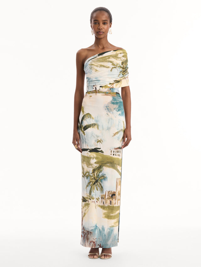 The model is wearing the Dominican Landscape Jersey Gown. Featuring a one-shoulder neckline and long, column silhouette. Front View.