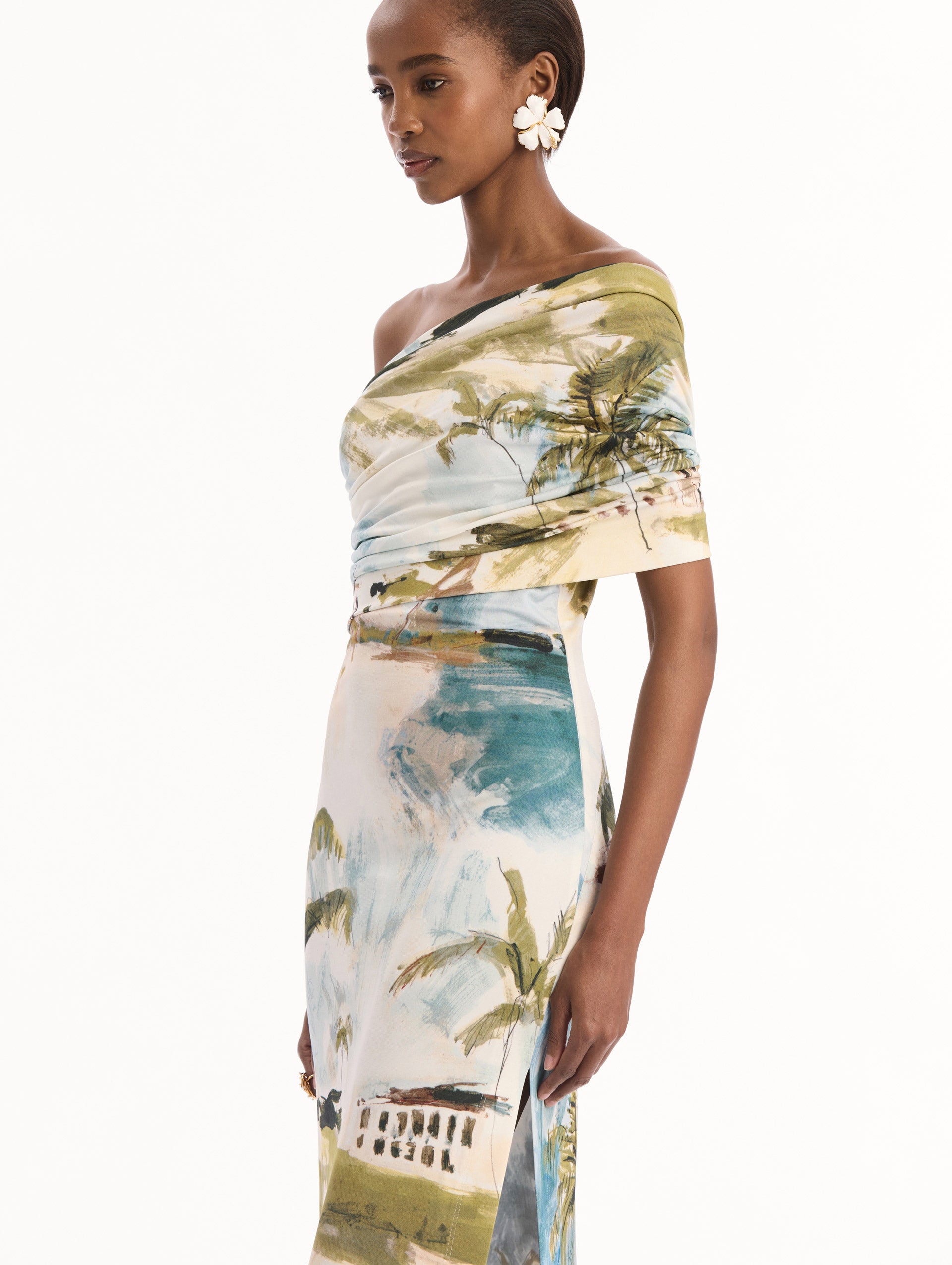 The model is wearing the Dominican Landscape Jersey Gown. Featuring a one-shoulder neckline and long, column silhouette. Detail View.