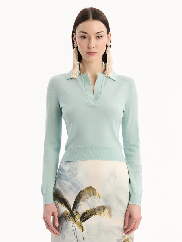 The model is wearing the Wool Polo Pullover in Saltwater Blue. Featuring an open color neckline, long sleeves, and ribbed trim. Front View.
