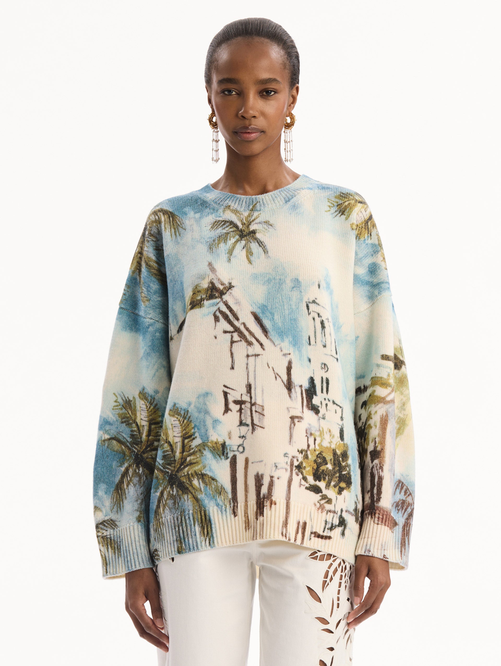 The model is wearing the Dominican Landscape Oversized Pullover. Featuring a crew neckline, long sleeves, ribbed trim, and an oversized fit. Front View.
