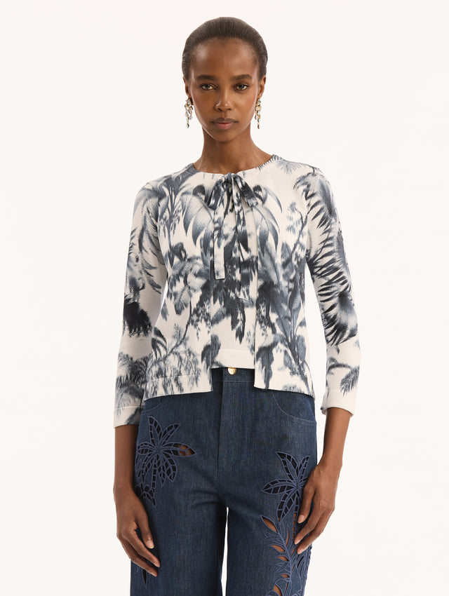 Ivory Three Quarter Length Sleeve Cardigan with Bow Tie Closure at Neck and Navy Chiné Palm Leaves Print. Front View. 