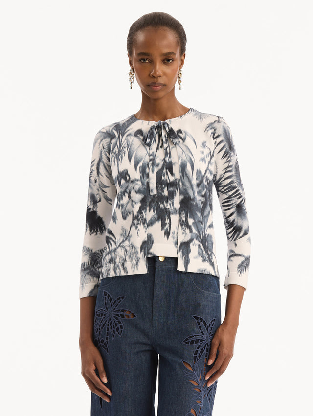 The model is wearing the Chiné Palm Leaves Cardigan in Navy and White. Featuring a crew neckline, quarter-length sleeves, banded trim, and tie front closure. Front View.