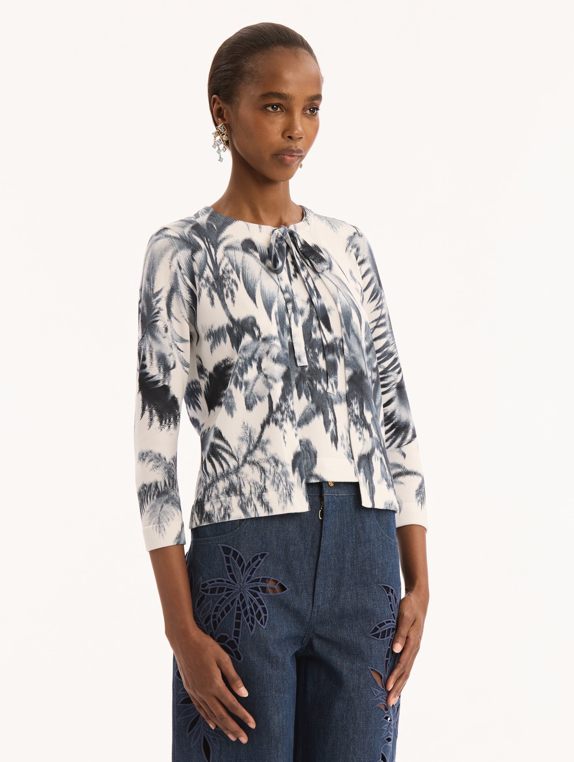 Ivory Three Quarter Length Sleeve Cardigan with Bow Tie Closure at Neck and Navy Chiné Palm Leaves Print. Side View. 