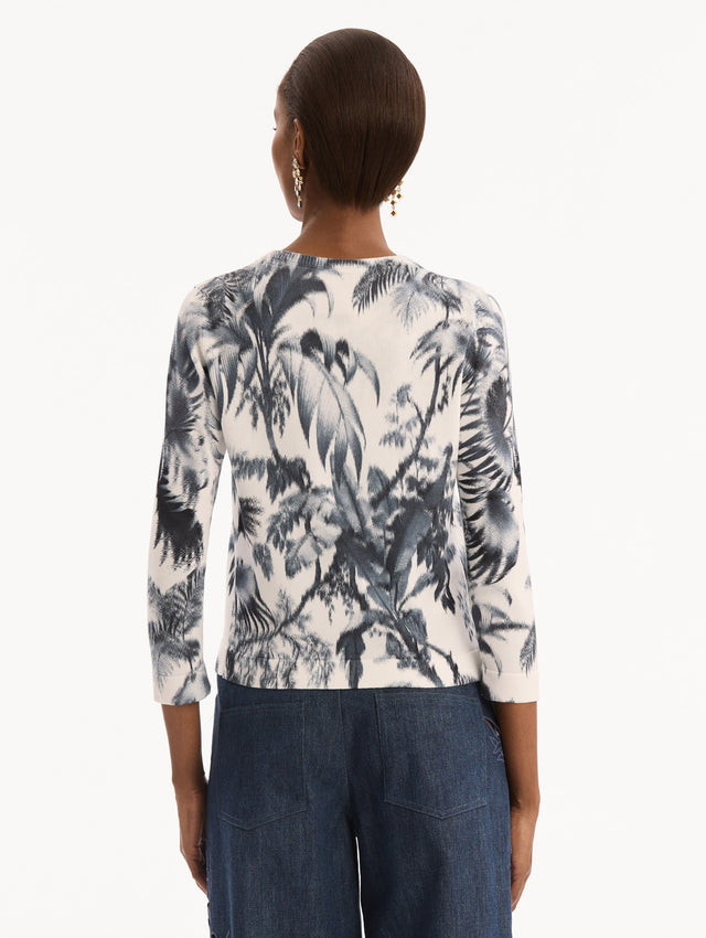 The model is wearing the Chiné Palm Leaves Cardigan in Navy and White. Featuring a crew neckline, quarter-length sleeves, banded trim, and tie front closure. Back View.