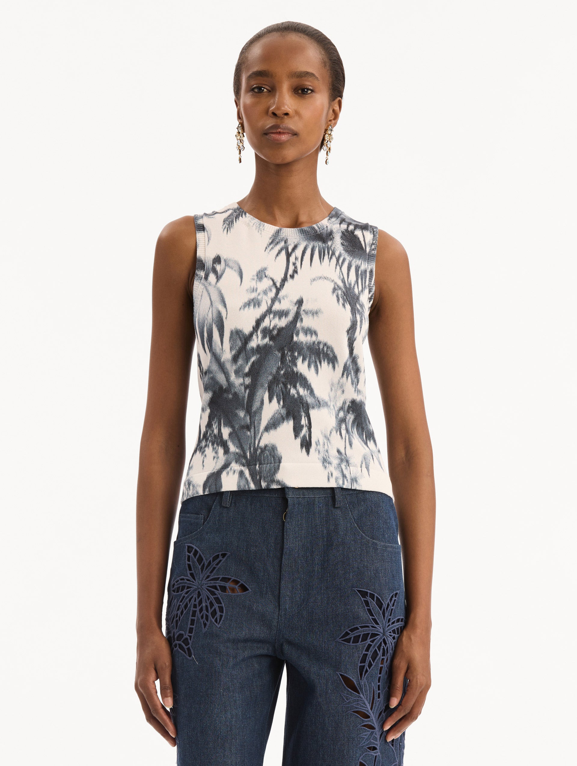 The model is wearing the Chiné Palm Leaves Tank in Navy and White. Featuring a crew neckline and banded trim. Front View.