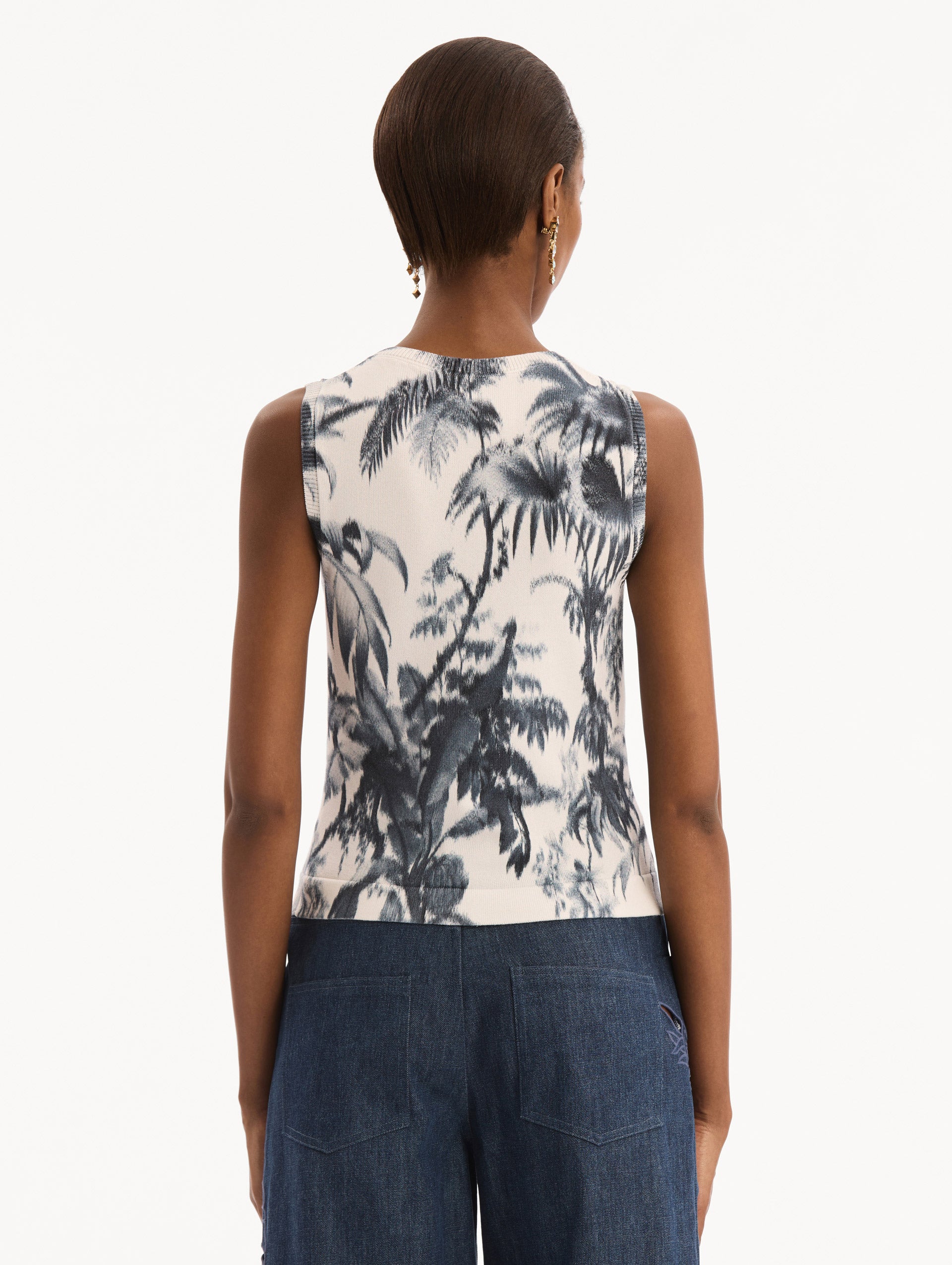 The model is wearing the Chiné Palm Leaves Tank in Navy and White. Featuring a crew neckline and banded trim. Back View.