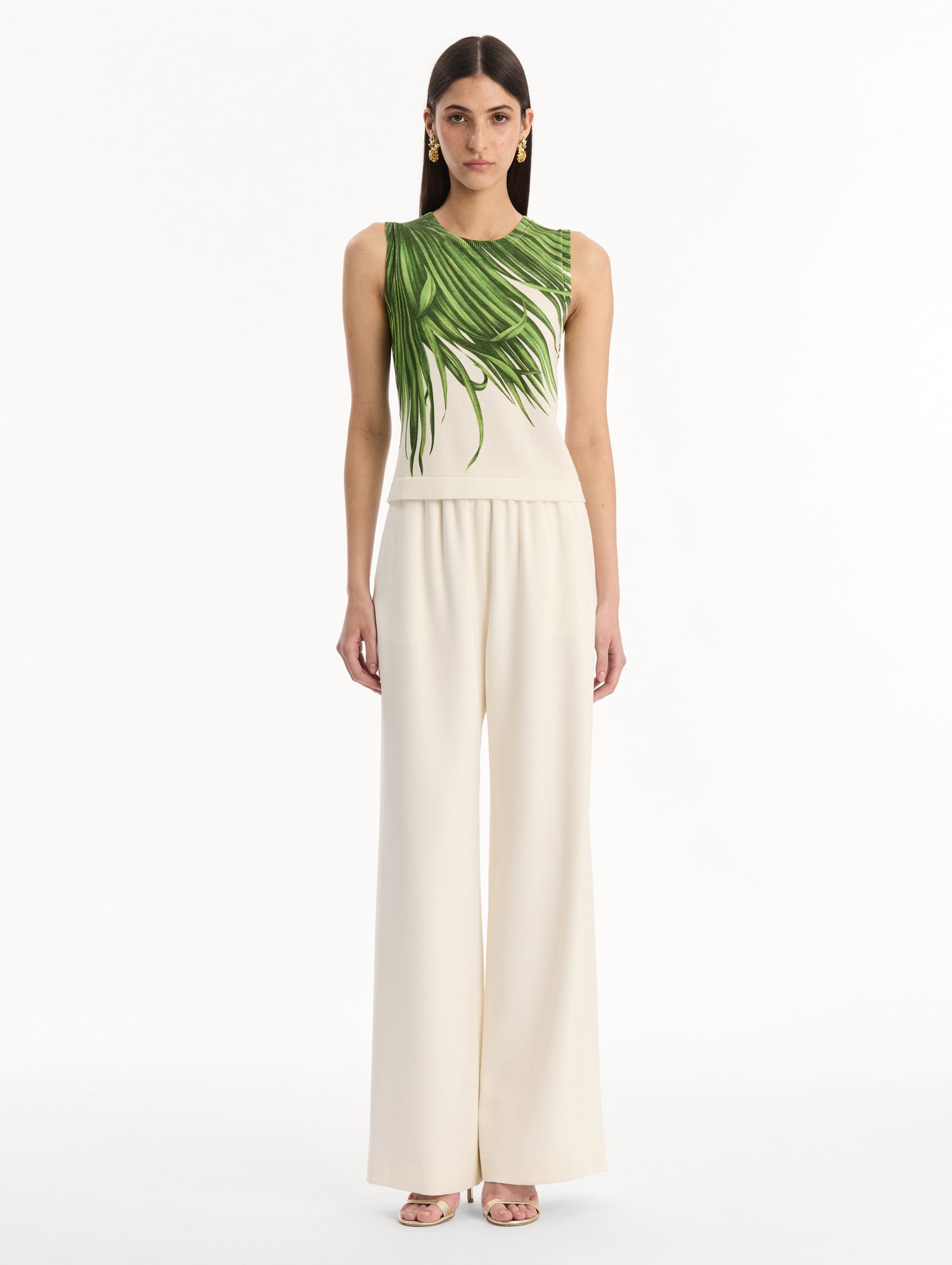 The model is wearing the Palm Leaves Tank in Green and Ivory. Featuring a crew neckline and banded trim. Front View.