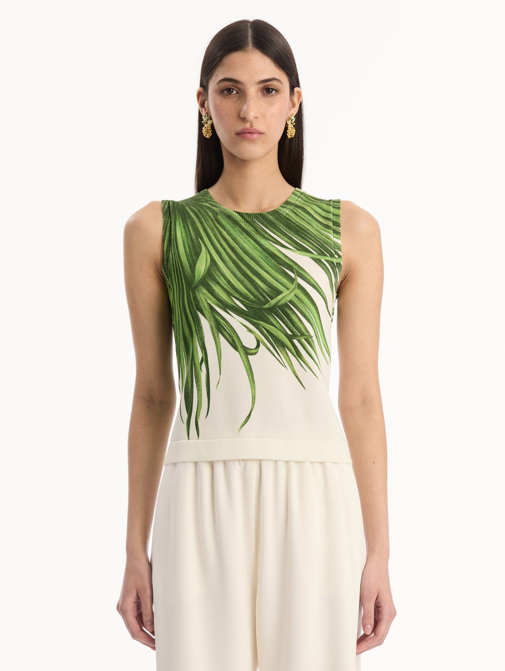 The model is wearing the Palm Leaves Tank in Green and Ivory. Featuring a crew neckline and banded trim. Front View.