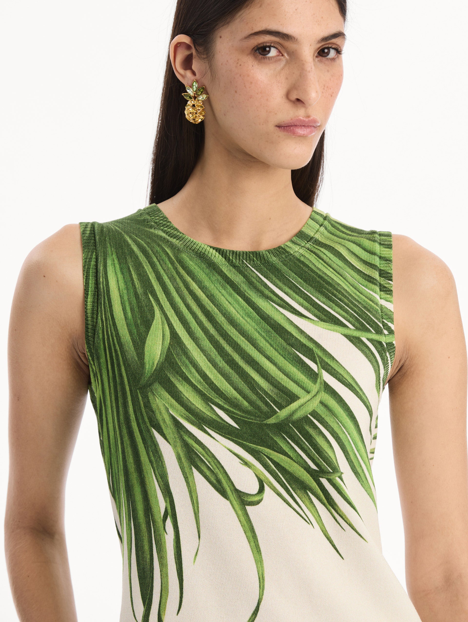 The model is wearing the Palm Leaves Tank in Green and Ivory. Featuring a crew neckline and banded trim. Detail View.