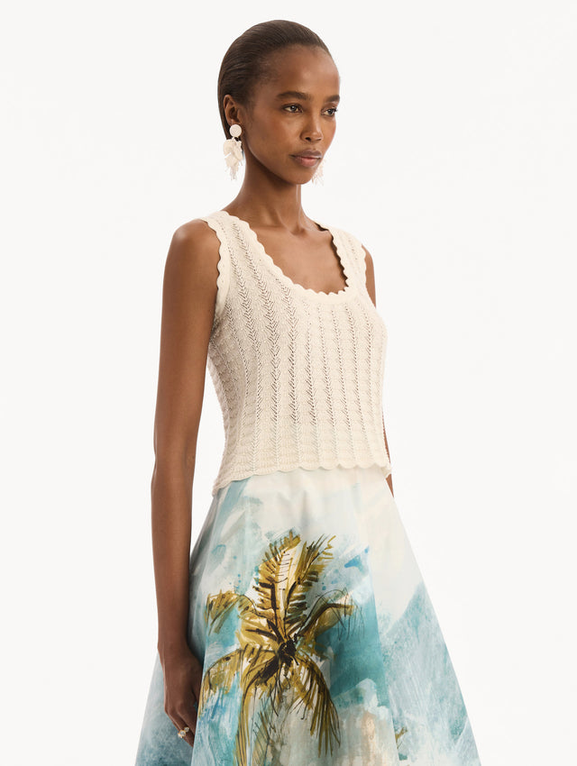 The model is wearing the Pointelle Weave Tank in Ivory. Featuring a scoop neckline, thick tank straps, and scalloped edges. Side View.