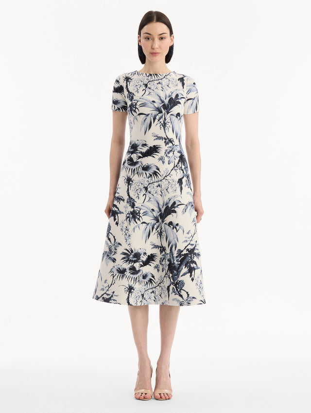 The model is wearing the Chiné Palm Leaves Knit Dress in Navy and Ivory. Featuring a classic silhouette with short sleeves and an A-line midi skirt. Front View.