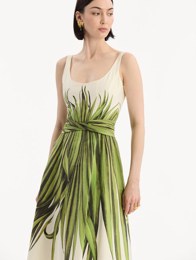 The model is wearing the Palm Leaves Cotton Poplin Dress. Featuring a scoop neckline, tank straps, cinched waist, and midi length. Detail View.