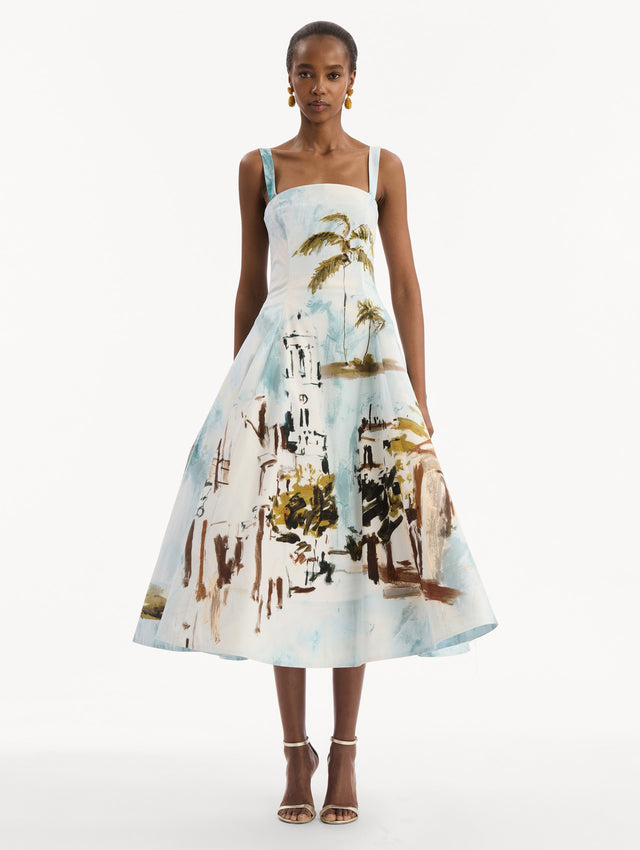 The model is wearing the Dominican Landscape Cotton Poplin Sleeveless Dress. Featuring tank straps with bow feature in back, and a full, midi-length skirt. Front View.
