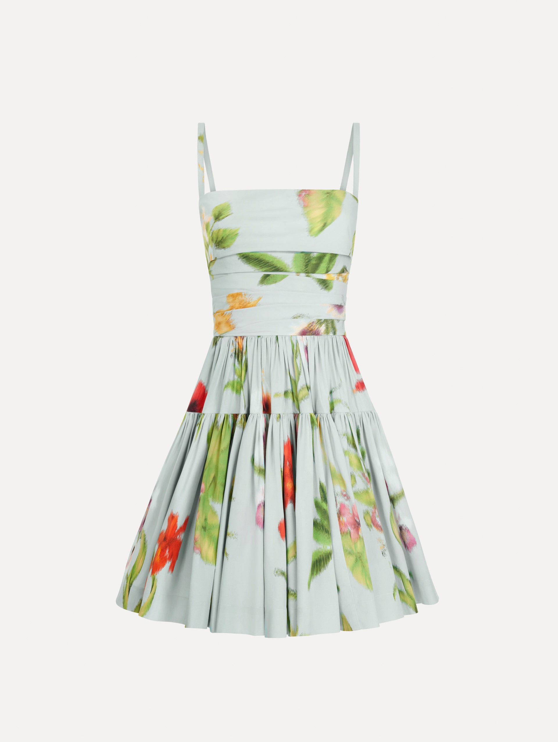 The Chiné Dominican Mixed-Floral Cotton Poplin Tiered Dress in light blue printed with a vibrant array of Dominican florals. Featuring a ruched bodice, tank straps, and gathered mini skirt. Front View.